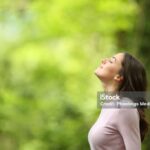 Profile of a relaxed woman breathing fresh air in a green forest